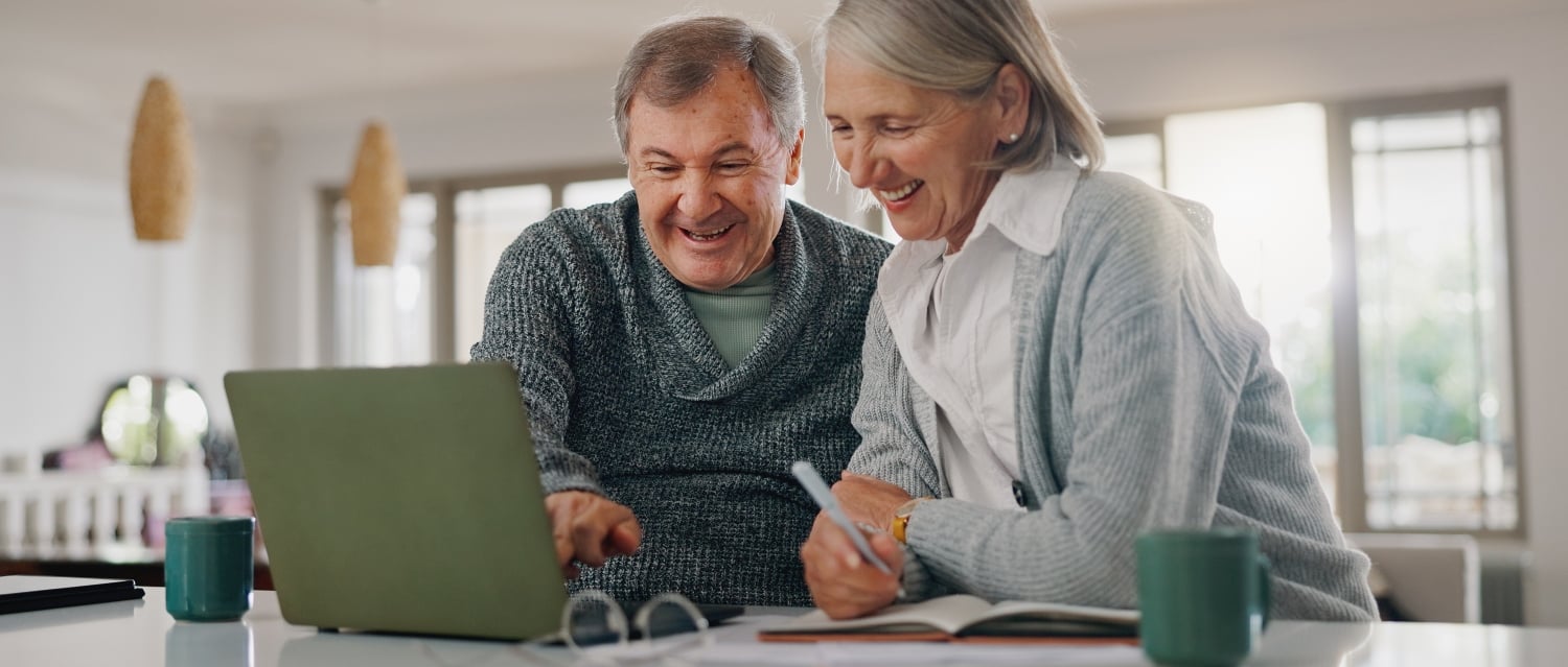 Smiling couple in front of a laptop
