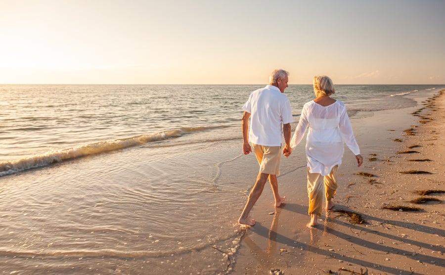 Senior couple holding hands on a beach